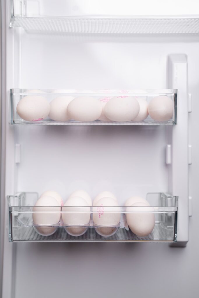 A refrigerator filled with lots of white eggs