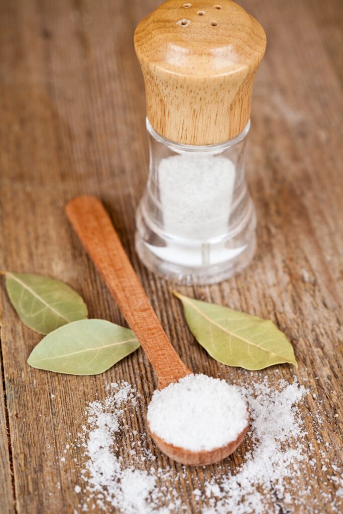 A salt shaker and a wooden spoon on a table