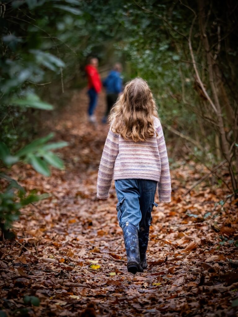Two people walking down a path in the woods