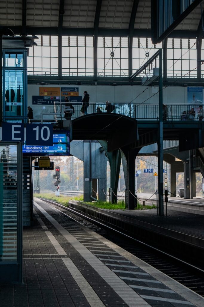 Train station platform with tracks and overhead bridge overhead structure