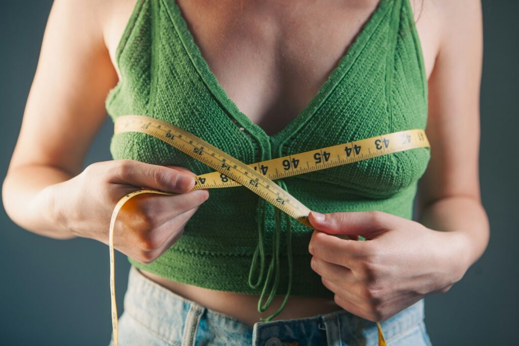 Woman measuring her bust with a tape measure