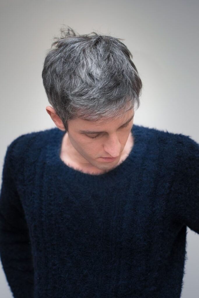 a man with grey hair is looking down