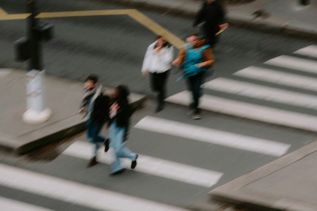a group of people walking across a cross walk