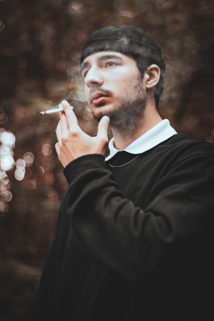 a man smoking a cigarette in a black jacket
