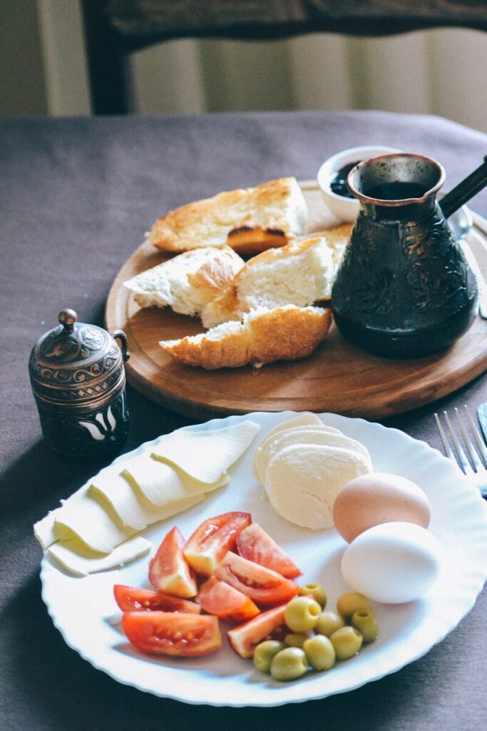 a plate of food with bread, olives, tomatoes and breadcrumbs